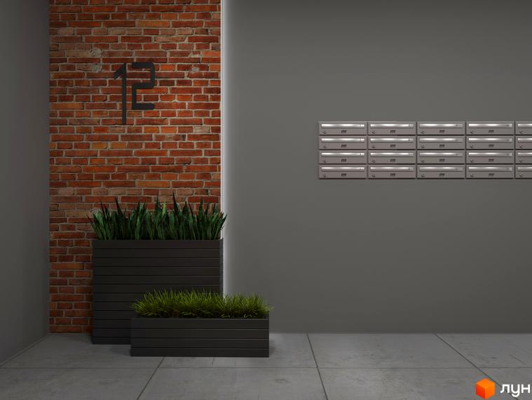 Зовнішній вигляд ЖК Клубне містечко 12 з цегляною стіною та поштовими скриньками. Прибудинкова територія з рослинами в ящиках.
