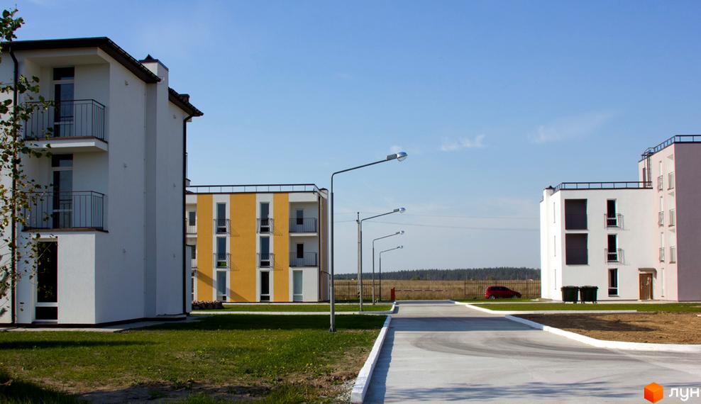 Зовнішній вигляд будинків Житлового комплексу Ясний. На фото видно багатоповерхівки з балконами та прибудинкову територію з дорогою.
