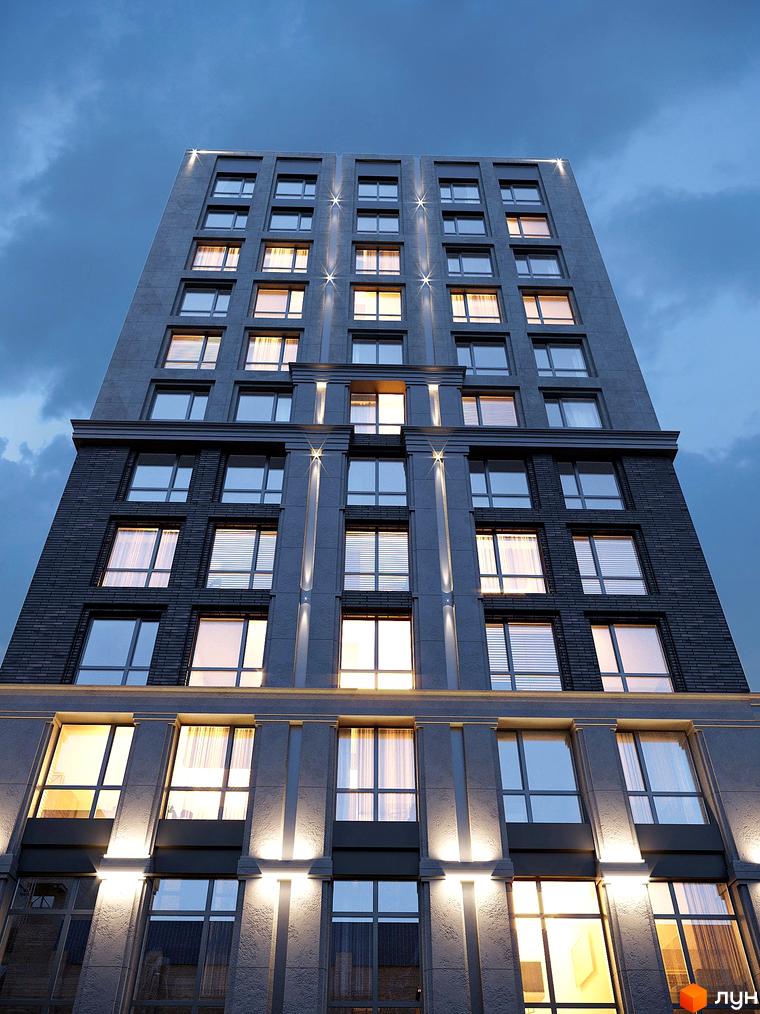 Зовнішній вигляд новобудови ЖК GENEVE з великою кількістю вікон та підсвіткою фасаду. Будинок має багатоповерхову структуру з сірим фасадом та темною цегляною облицовкою нижніх поверхів.