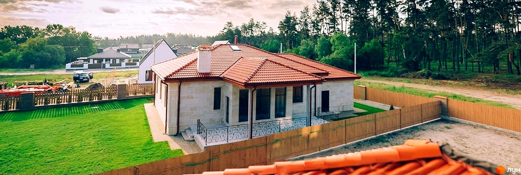 Котеджне містечко КМ Villa Grace: одноповерховий будинок з червоним черепичним дахом, білими стінами та огородженою зеленою ділянкою.