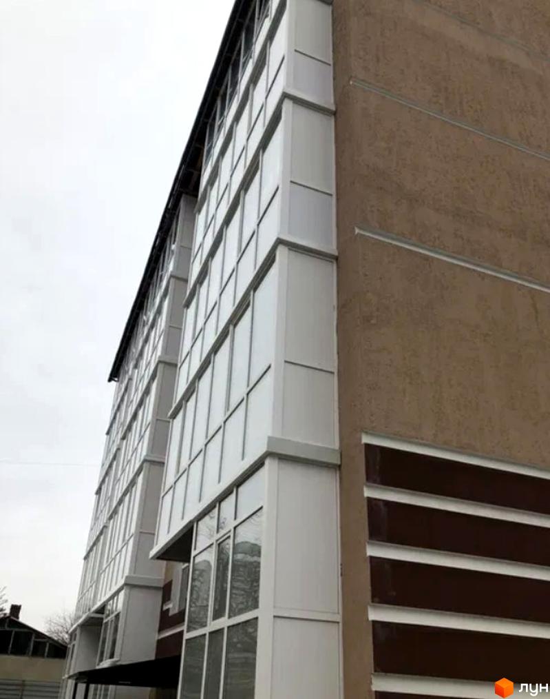 Зовнішній вигляд багатоквартирного будинку на вул. Полтавський Шлях, 177в. Сучасна архітектура з панорамним склінням та коричневими елементами фасаду.