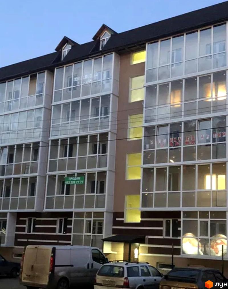 Фасад новобудови на вул. Полтавський Шлях, 177в, з великими заскленими балконами та прибудинковою територією з автомобілями.