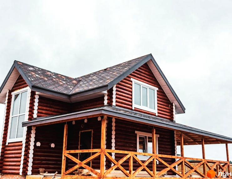 Котеджне містечко Святобор: двоповерховий дерев'яний будинок з терасою та балконом під двосхилим дахом.