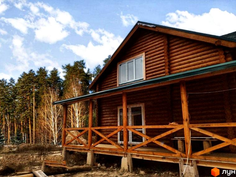 Дерев'яний будинок з верандою на фоні лісу. Котеджне містечко Святобор - затишна новобудова для вашого життя.