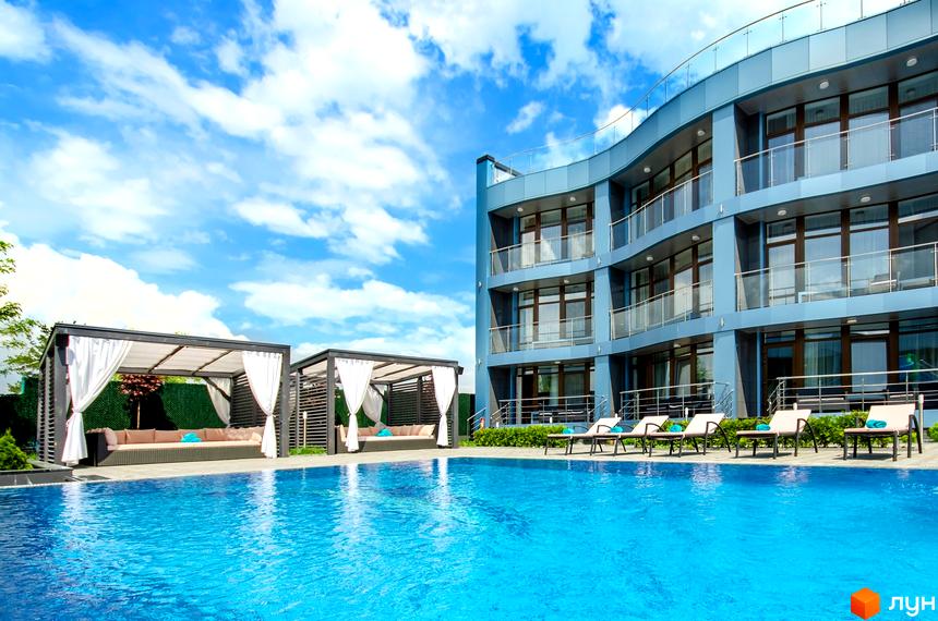 Будівельний проєкт Sky River з блакитною фасадною частиною та балконами, басейном та зонами відпочинку з навісами.