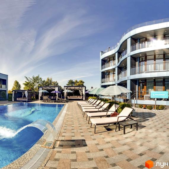 Житловий комплекс Sky River з блакитною будівлею та басейном з шезлонгами. На території розташовані альтанки та зона відпочинку біля води.