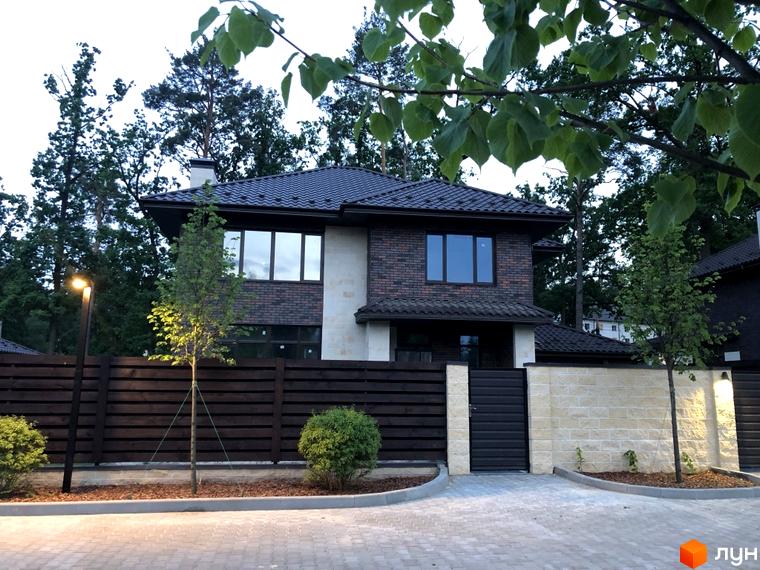 Котеджне містечко КМ Zahrava Village з цегляним фасадом та темним дахом. Огороджена територія з бруківкою та освітленням.