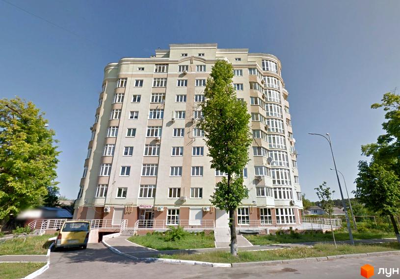 Зовнішній вигляд новобудови на вул. Михайла Драй-Хмари (Тухачевського), 44, з прибудинковою територією та деревами. Багатоповерховий будинок світло-бежевого кольору з великою кількістю вікон та балконів.