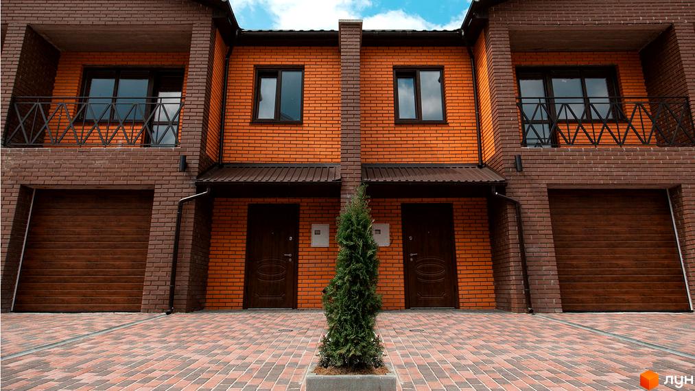 Котеджне містечко Затишне: фасади будинків з цегли, гаражні ворота та доріжка з бруківки. Зовнішній вигляд новобудови та прибудинкової території.