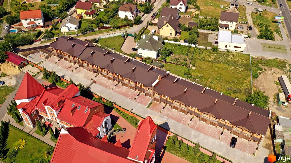 Котеджне містечко Затишне: огляд таунхаусів з коричневими дахами та прибудинковою територією. На фото видно зелені насадження та дороги.