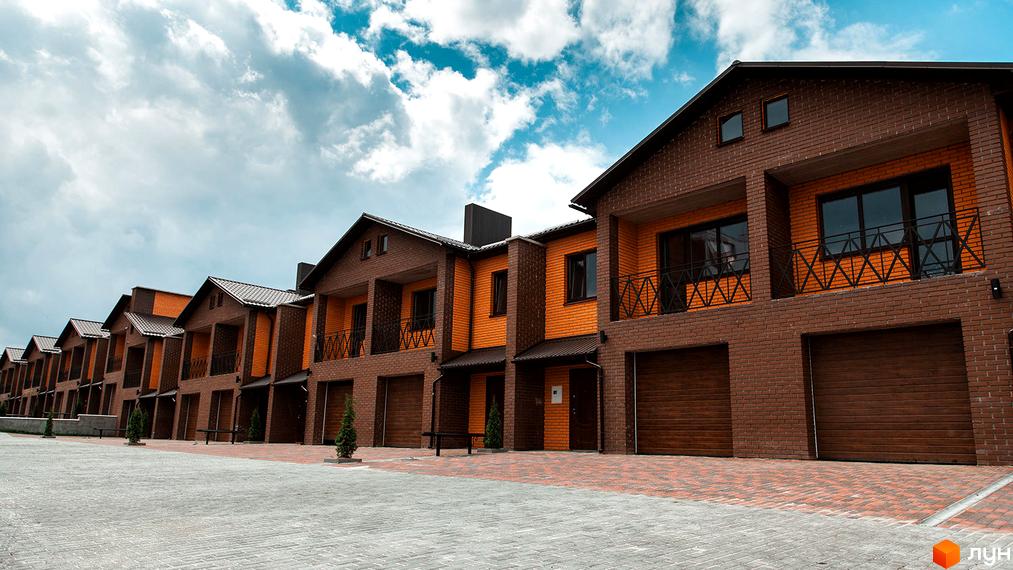 Котеджне містечко Затишне - сучасна котеджна забудова з цегляними фасадами та індивідуальними гаражами. Перед будинками розташована брукована прибудинкова територія з зеленими насадженнями.