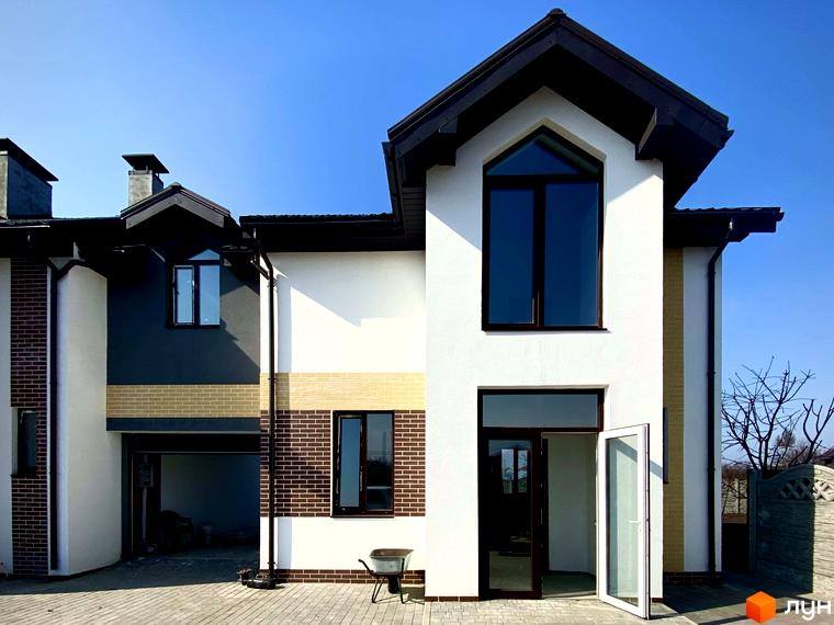 Зовнішній вигляд Таунхаус „Соборний“ з цегляними та білими фасадами, великими вікнами та дверима. Прибудинкова територія з бруківкою та елементами ландшафтного дизайну.