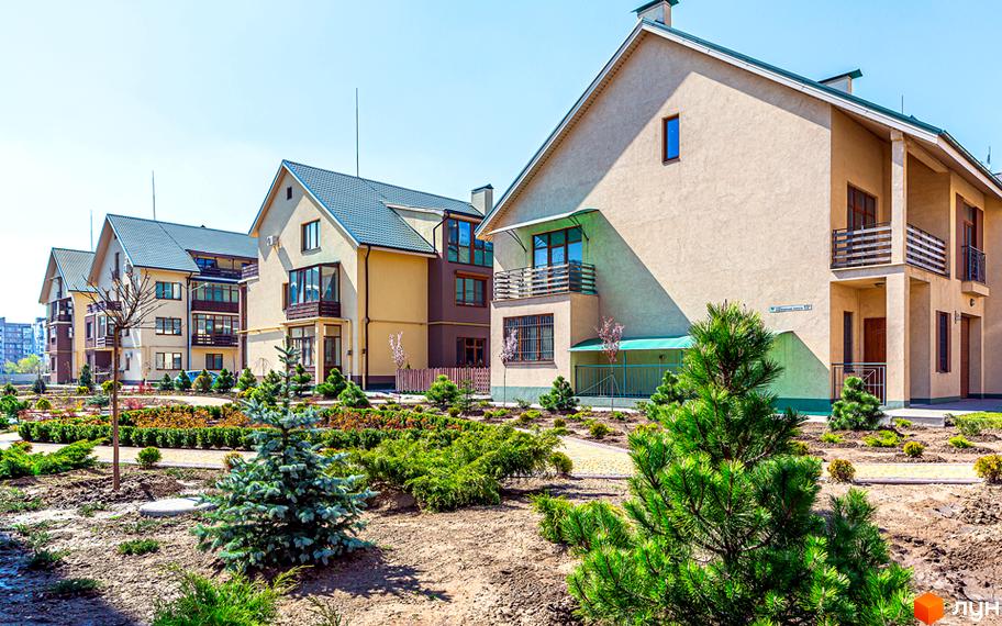 Зовнішній вигляд будинків житлового комплексу Бородино з зеленими насадженнями та доглянутою територією.