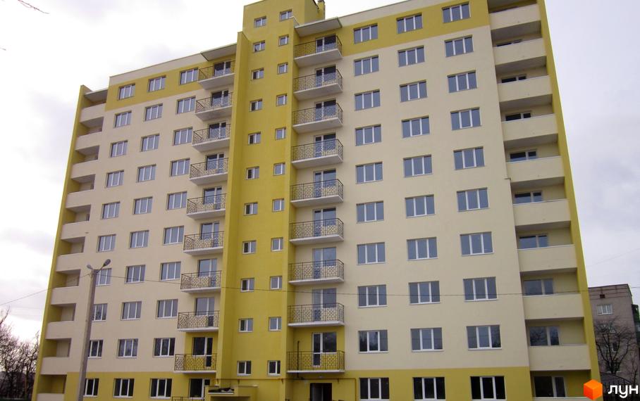 Зовнішній вигляд новобудови на вул. Європейська, 84/3, з жовто-бежевим фасадом та балконами. Будівельний проєкт з великою кількістю вікон.