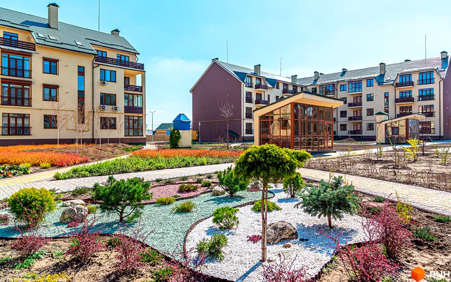 Житловий комплекс Бородино. Зовнішній вигляд будівель з балконами та вікнами, прибудинкова територія з ландшафтним дизайном та зеленими насадженнями.