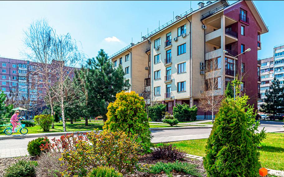 Житловий комплекс Бородино: багатоповерхові будинки з балконами та кондиціонерами, зелена прибудинкова територія з деревами та кущами, дитина катається на велосипеді.
