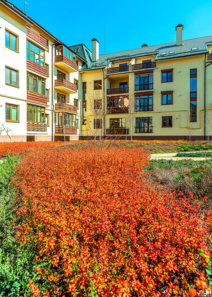 Житловий комплекс Бородино: світлі фасади, дерев'яні елементи, балкони та зелена прибудинкова територія з червоним листям.