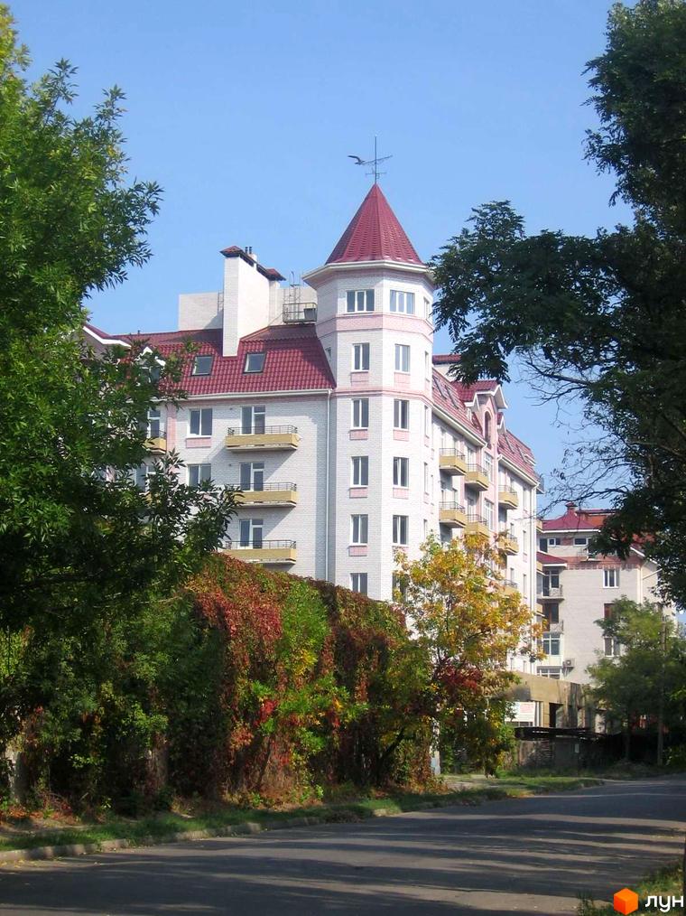 Житловий комплекс на вулиці Грецькій, 47, з багатоповерховими будинками та червоними дахами, оточений зеленню та деревами.