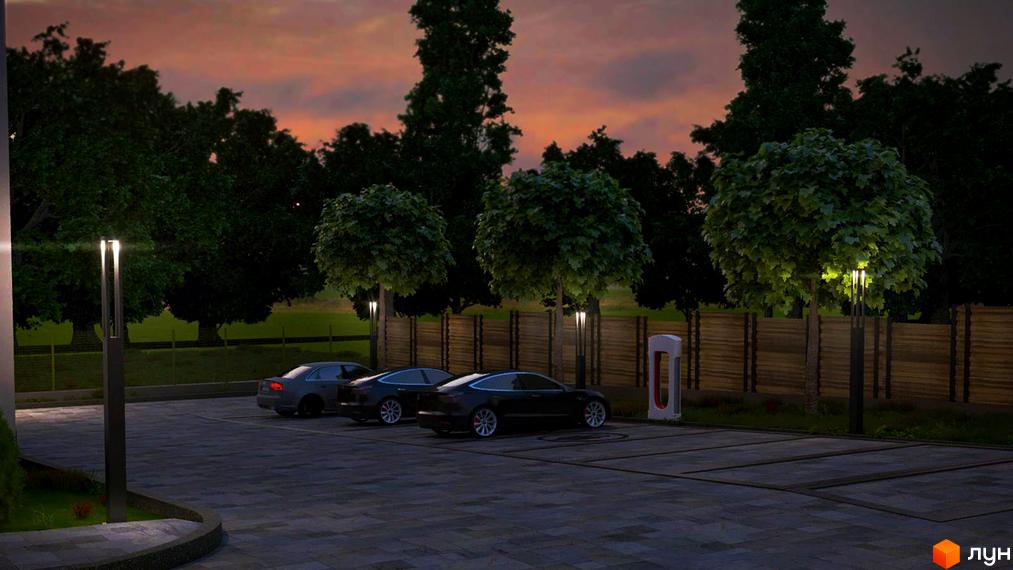 Житловий комплекс ECOtown: парковка з електромобілями та зарядними станціями біля будівель. Прибудинкова територія з освітленням та деревами.