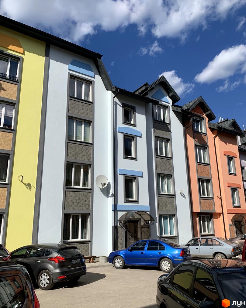 Житловий комплекс Мала Швейцарія: яскраві фасади будинків та парковка з автомобілями. Зовнішній вигляд новобудови та прибудинкова територія.