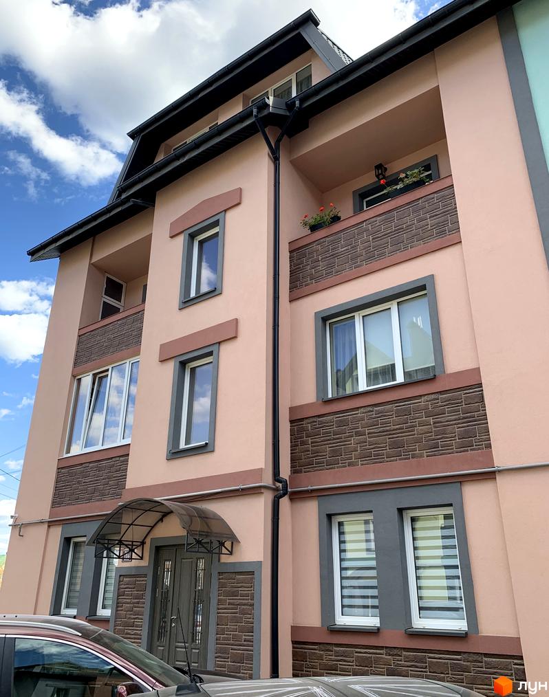 Фасад будинку ЖК Мала Швейцарія з вікнами та балконами. Зовнішній вигляд новобудови з елементами декору.