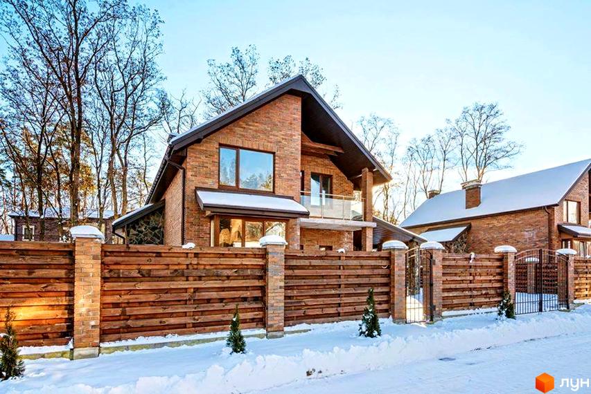 Котеджне містечко КМ Парк хаус. Двоповерхові цегляні будинки з темним дахом та дерев'яним парканом. Прибудинкова територія вкрита снігом.