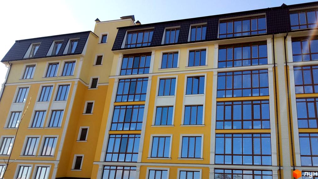 Житловий комплекс Club Marine – багатоповерхова новобудова з жовтим фасадом, великими вікнами та темним скатним дахом. Зовнішній вигляд будівлі приваблює своєю симетрією та чіткими лініями.