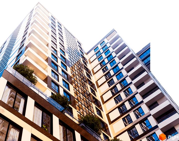 Зовнішній вигляд житлового комплексу High Hills з численними балконами та панорамними вікнами. Вид знизу на багатоповерховий будинок.