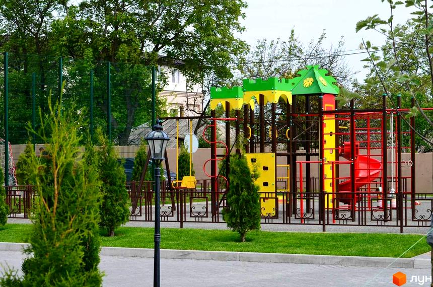Дитячий майданчик у Містечку котеджів Palaris. На території комплексу є зелені насадження та вуличне освітлення.