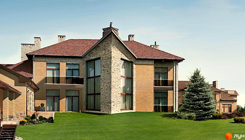 Котеджне містечко КМ Сонячна долина. Фасад будинку з цегли та каменю, великі вікна, зелений газон та дерева.