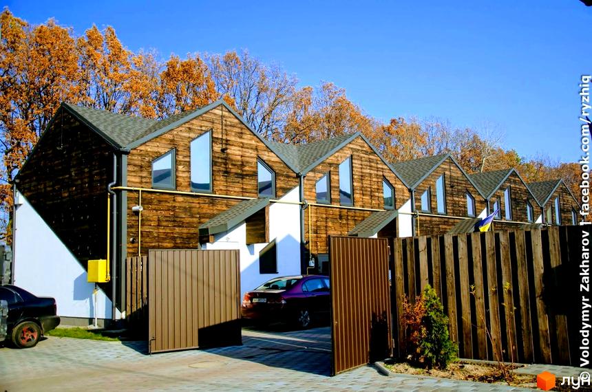 Зовнішній вигляд таунхаусів «Кримський квартал» з дерев'яним оздобленням та великими вікнами. На передньому плані – доглянута територія.