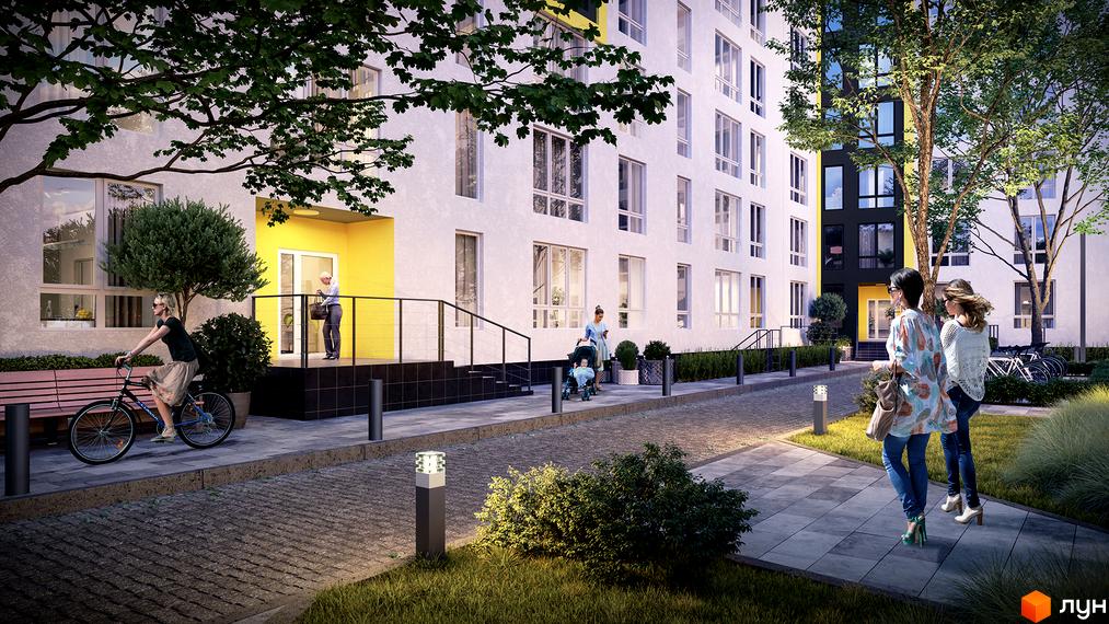 Біла будівля ЖК Шенген з великими вікнами та жовтим акцентом на вході. На прибудинковій території бруківка, зелені насадження та ліхтарі.