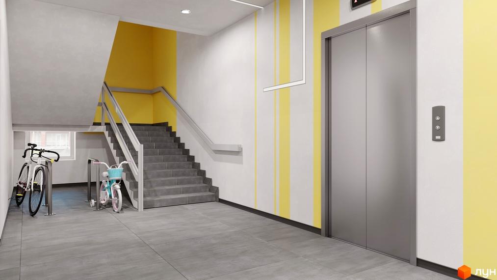 Просторий хол в ЖК Шенген з ліфтом, сходами та місцем для велосипедів. Сіра плитка на підлозі, стіни пофарбовані в білий та жовтий кольори.