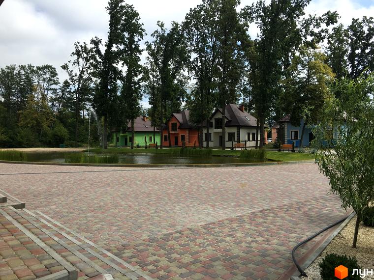 Котеджне містечко Козак хутір: затишні будинки біля озера з фонтаном, вимощені доріжки та зелені насадження. Фото комплексу.