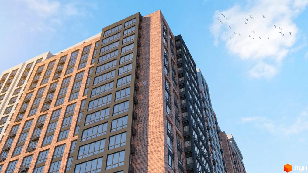 Зображення фасаду Новобудови Оскар з великими вікнами та цегляним оздобленням. Навколо блакитне небо та зграя птахів.