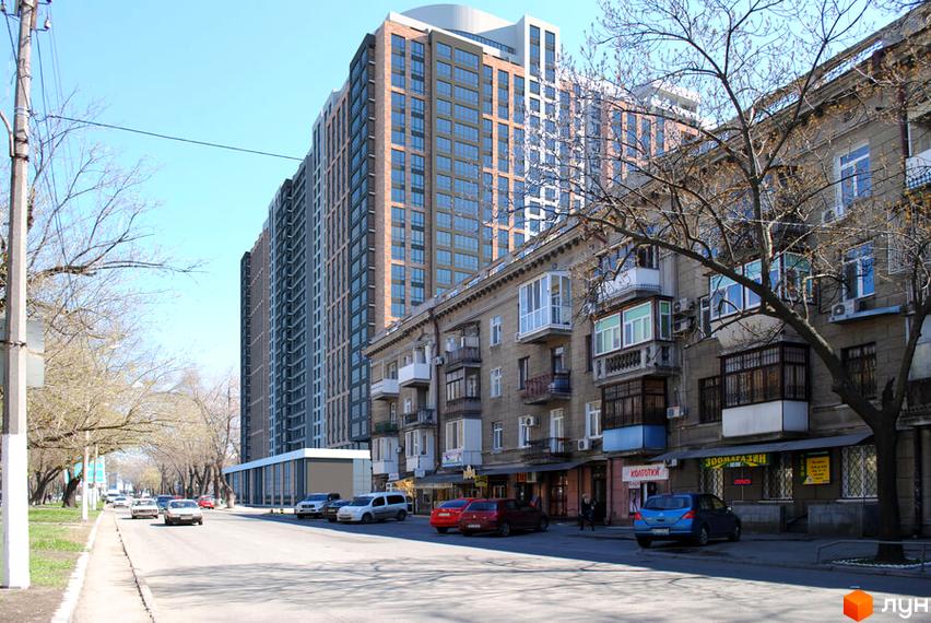 Зображення фасаду Житлового комплексу Оскар. Висотна будівля з великою кількістю вікон на фоні міської вулиці.