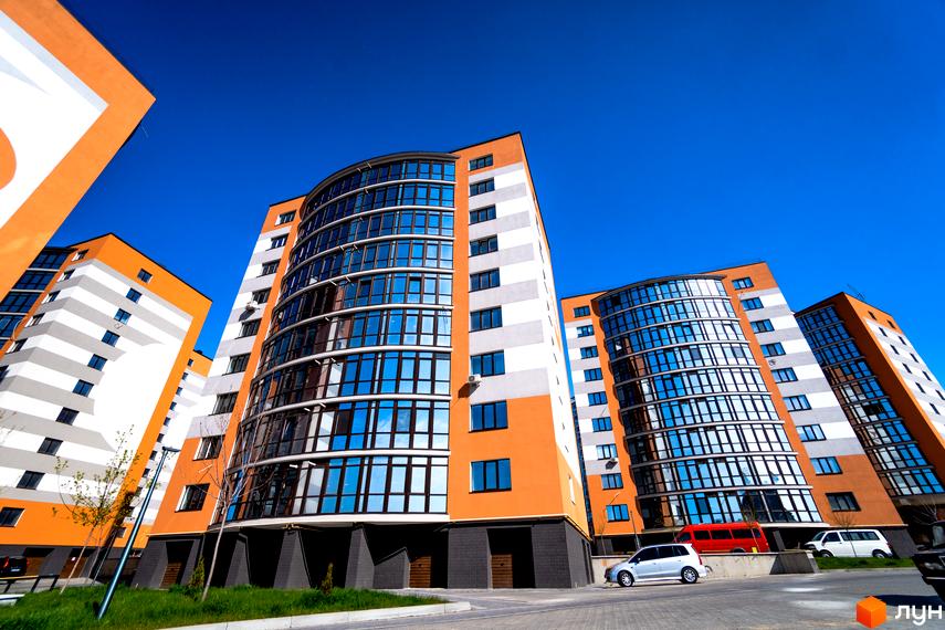 Зображення фасаду будинків Житлового комплексу Містечко Соборне. На фото видно багатоповерхівки з великими вікнами та прибудинкову територію.