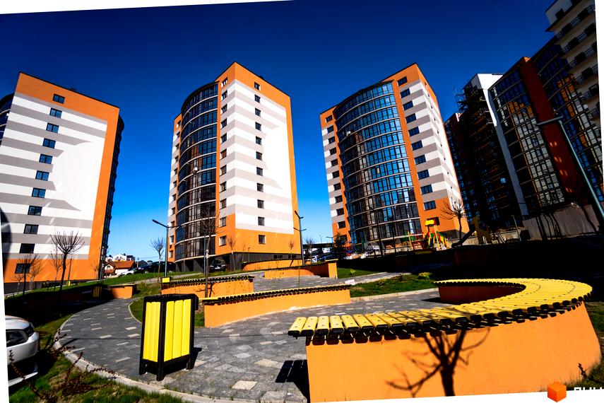 Зображення житлового комплексу Містечко Соборне. Вигляд багатоповерхових будинків з помаранчевим оздобленням та облаштованою прибудинковою територією.