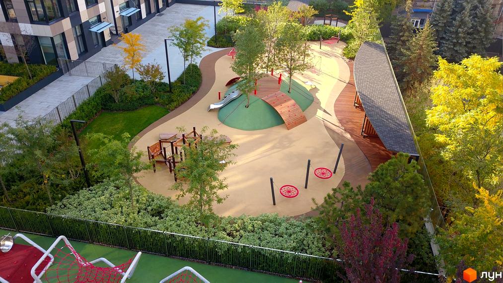 Житловий комплекс Tetris Hall. Дитячий майданчик з гіркою, гойдалками та пісочницею на фоні багатоповерхових будинків.