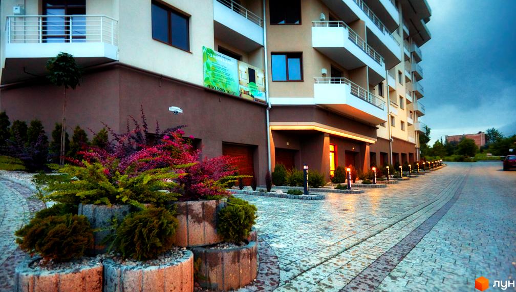 Житловий комплекс GREEN LAND: фасади будівель з балконами, прибудинкова територія з ландшафтним дизайном та освітленням.