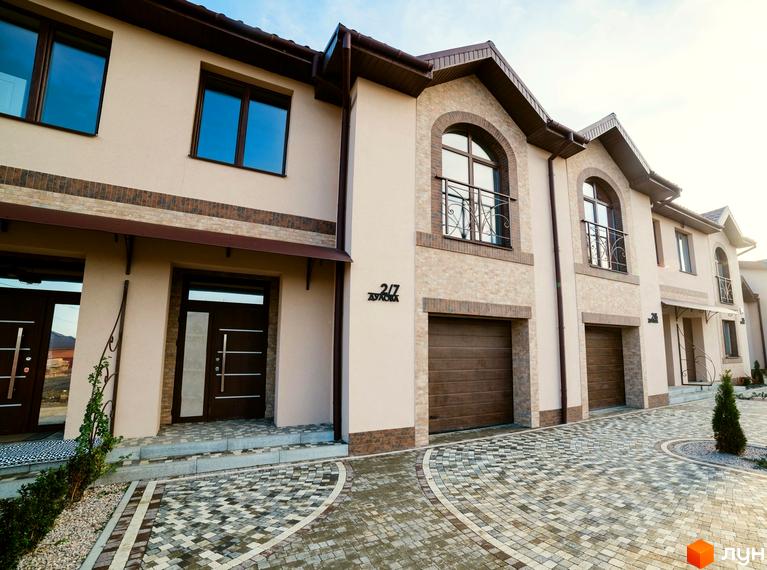 Таунхаус „ДУЛОВА“: двоповерхові будинки з цегляним оздобленням та індивідуальними гаражами. Прибудинкова територія вимощена бруківкою.