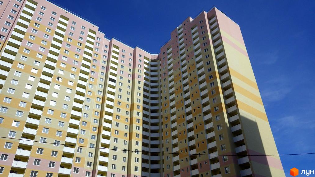 Житловий комплекс Милославичі з яскравими фасадами та балконами. Прибудинкова територія з зеленими насадженнями та зручними доріжками.