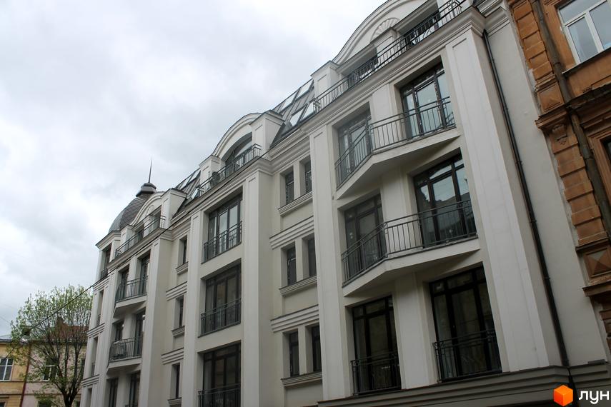 Апарт-комплекс Чайковського, 31 – це біла багатоповерхова новобудова з балконами та великими вікнами під сірим небом.