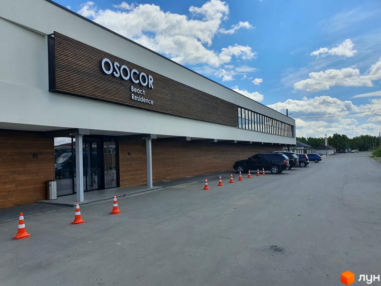 Фасад будівлі Комплекс Осокор з вивіскою та парковкою. На території розміщені дорожні конуси.