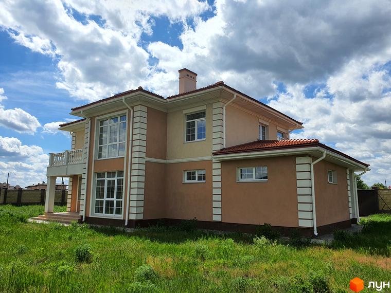 Зображення двоповерхового будинку з терасою в Котеджному містечку Осокор. Вигляд фасаду будинку та зеленої прибудинкової території.