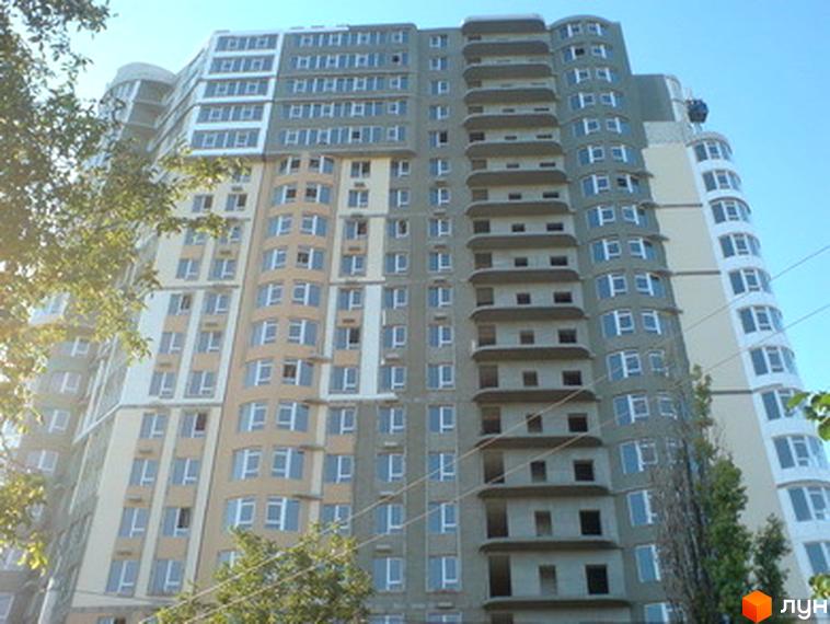 Житловий комплекс Фонтан з фасадом, що поєднує різні кольори. Прибудинкова територія з зеленими насадженнями.