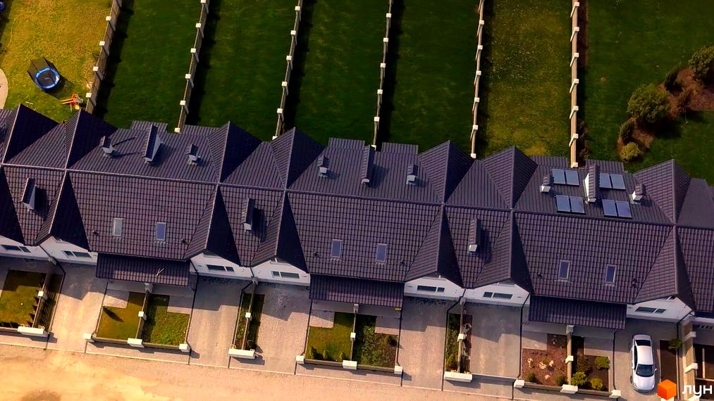 Зображення таунхаусів Житлового комплексу „Екологічний“ (Рибацька) з темними дахами та зеленими газонами. Вид зверху на будівлі та подвір'я.