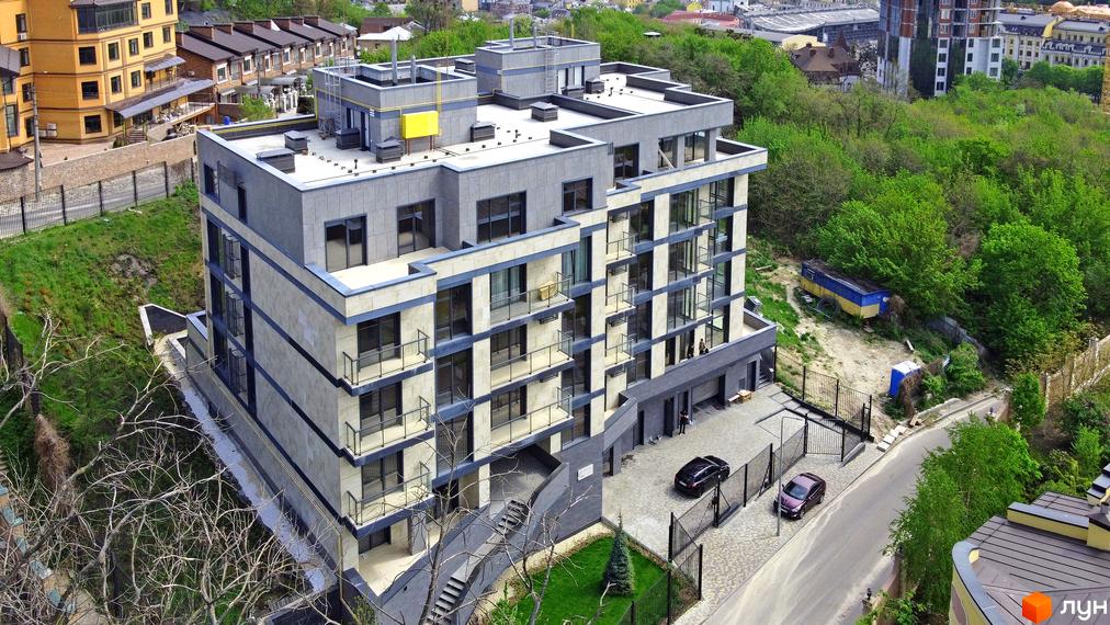 Зображення будинку InCo Home на Подолі. Багатоповерхова будівля з балконами та великими вікнами, поруч розташована прибудинкова територія з деревами та газоном.