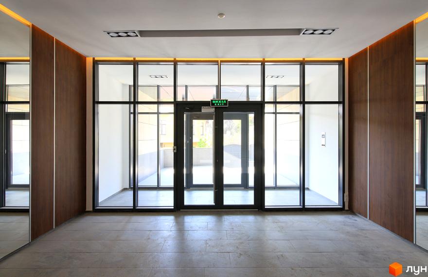 Зображення вхідної групи Житлового комплексу „InCo Home на Подолі“. Вихід з будівлі через скляні двері.