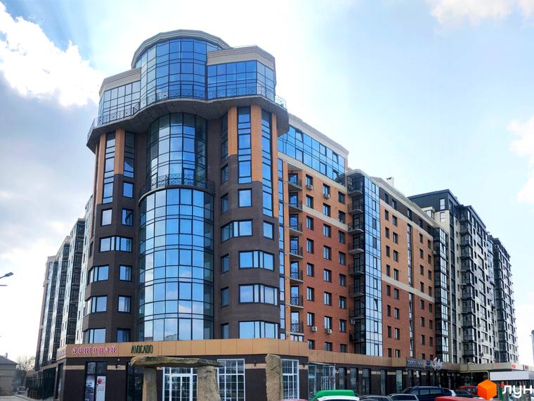 Житловий комплекс Яровиця: багатоповерхова новобудова з цегляним фасадом, скляними елементами та балконами. Зовнішній вигляд будівлі.